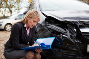 Female Loss Adjuster Writing Report On Damaged Car